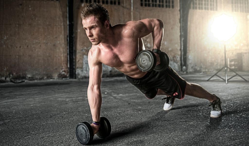 man doing push ups with weights